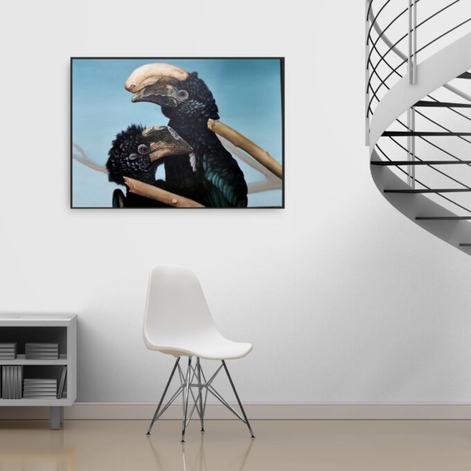 Galeria Wiele Sztuki, obraz olejny przedstawiający Dzioborożce srebrnolice, gatunek egzotycznego afrykańskiego ptaka. Wizualizacja przedstawia obraz wiszący na ścianie, nad krzesłem i obok krętych schodów.