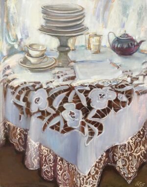 Na zdjęciu jest przedstawiony intymny obraz olejny, na którym widzimy bogato zastawiony stół przykryty haftowanym obrusem. Delikatne pastelowe kolory i subtelne światłocienie nadają dziełu niezwykłą głębię. To klasyczna martwa natura, która wprowadzi do każdego wnętrza nutkę nostalgii i elegancji.