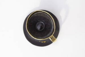 Piękna, elegancka, czarna ze złoceniami filiżanka z talerzykiem, do pojedynczego lub podwójnego espresso z serii Książę. Widok na filiżankę od góry. Filiżanka jest dostępna w Galerii Wiele Sztuki.