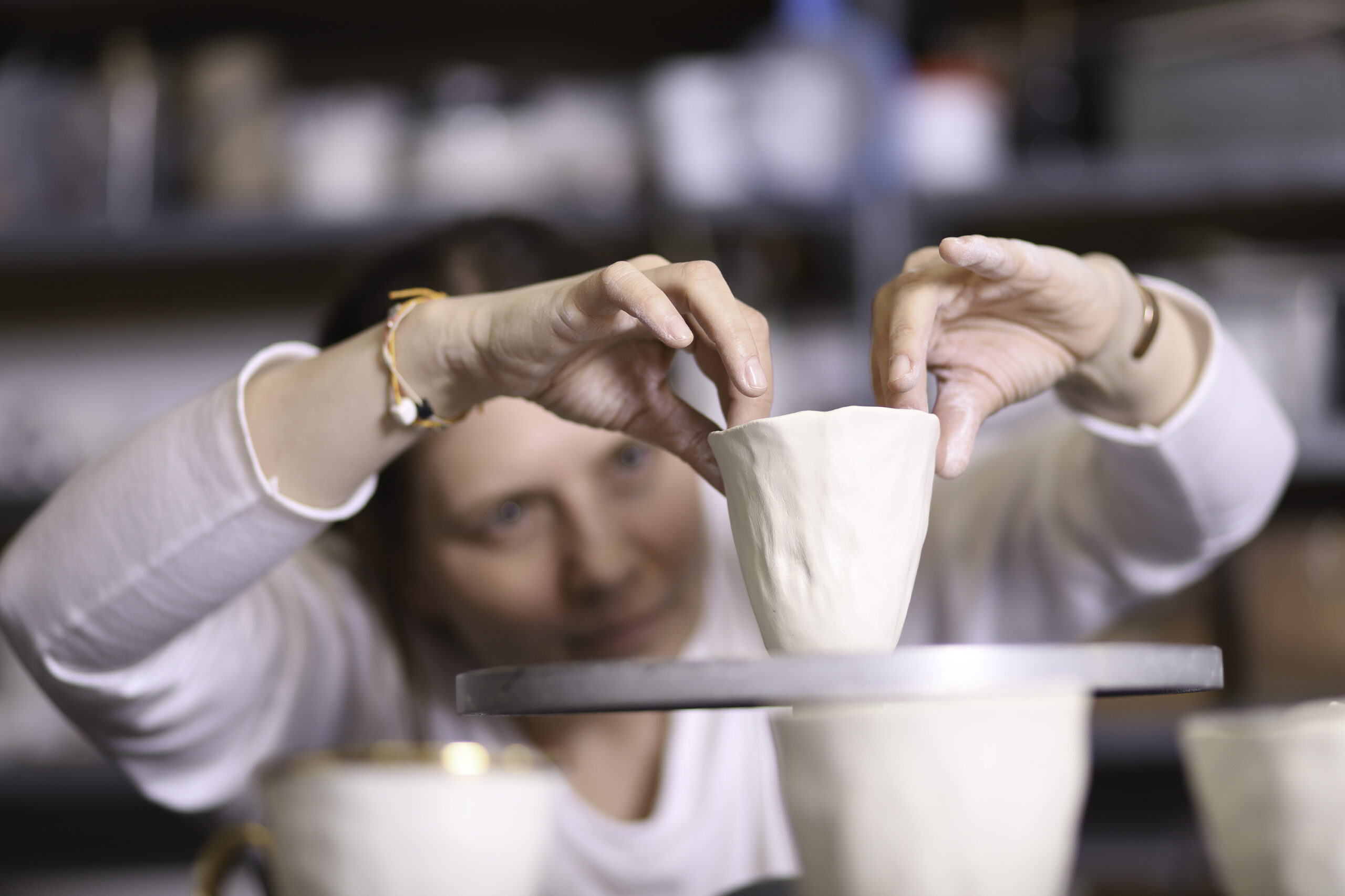 Artystka Magdalena Konior w swojej pracowni podczas produkcji artystycznej porcelany. Zdjęcie do biogramu artystki na stronie internetowej Galerii Wiele Sztuki. 