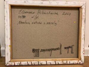 Na zdjęciu jest widoczne odwrocie (tylna strona płótna) obrazu olejnego autorstwa białoruskiej malarki Eleanory Bubashkiny, pod tytułem „Martwa natura z morelą”. Na zdjęciu widać napisane ręcznie przez malarkę: imię i nazwisko artystki, tytuł obrazu, jego wymiary, technikę i rok powstania. Sygnatury są umieszczone wzdłuż górnej krawędzi płótna. Obraz jest dostępny w Galerii Wiele Sztuki.