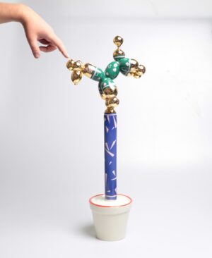 Nowoczesna rzeźba ceramiczna 'Flora Beta' Mariusza Dydo, przedstawiająca pieska-akrobatę na niebieskim słupku w doniczce, pop-art, Galeria Wiele Sztuki.