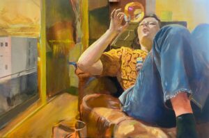 Obraz Bartosza Kościołka „Środek relaksujący”, współczesne malarstwo figuralne, portret młodej kobiety odpoczywającej w fotelu i puszczającej bańki mydlane, widok na blokowisko za oknem, intensywne żółte i pomarańczowe światło, olej na płótnie, Galeria Wiele Sztuki.