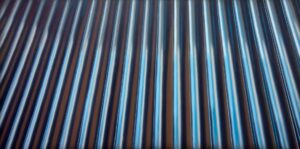 Obraz akrylowy na płótnie Jakuba Łącznego „Blacha”, współczesna abstrakcja, pionowe lśniące pasy w odcieniach chłodnego błękitu i antracytu, dostępny w ofercie Galerii Wiele Sztuki.